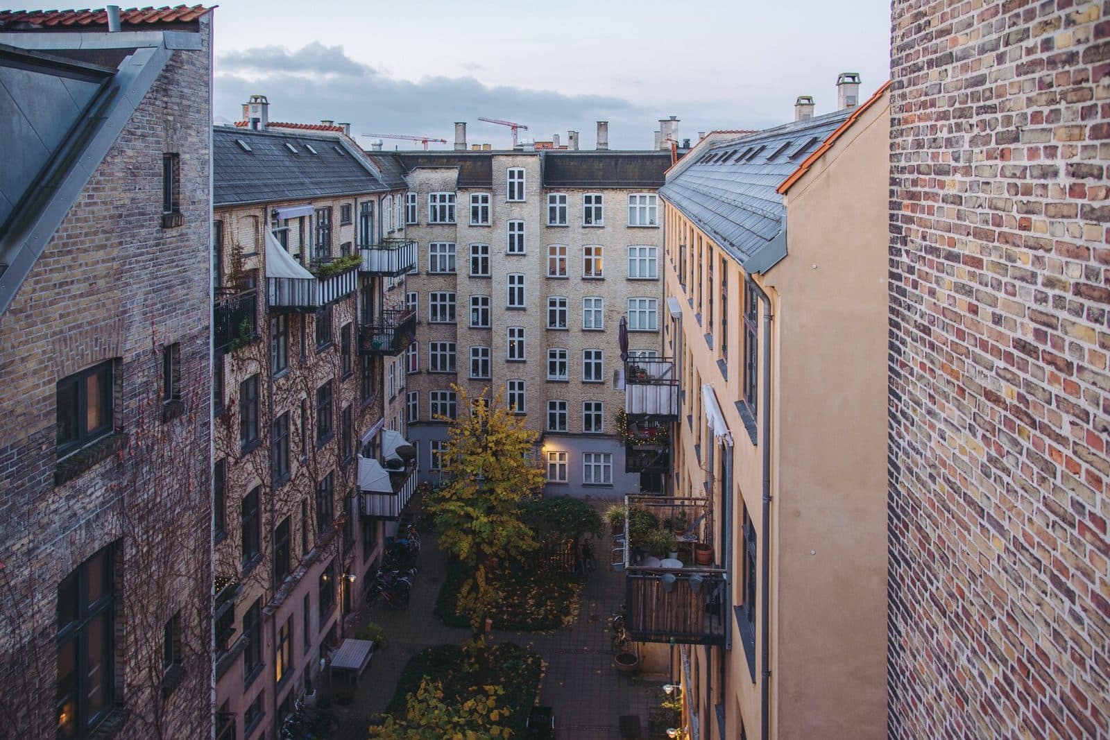 En baggård i København med røde murstensfacader, altaner og cykler